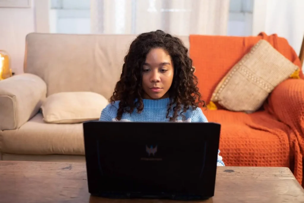 Uma jovem utiliza o notebook para se relacionar com outros.