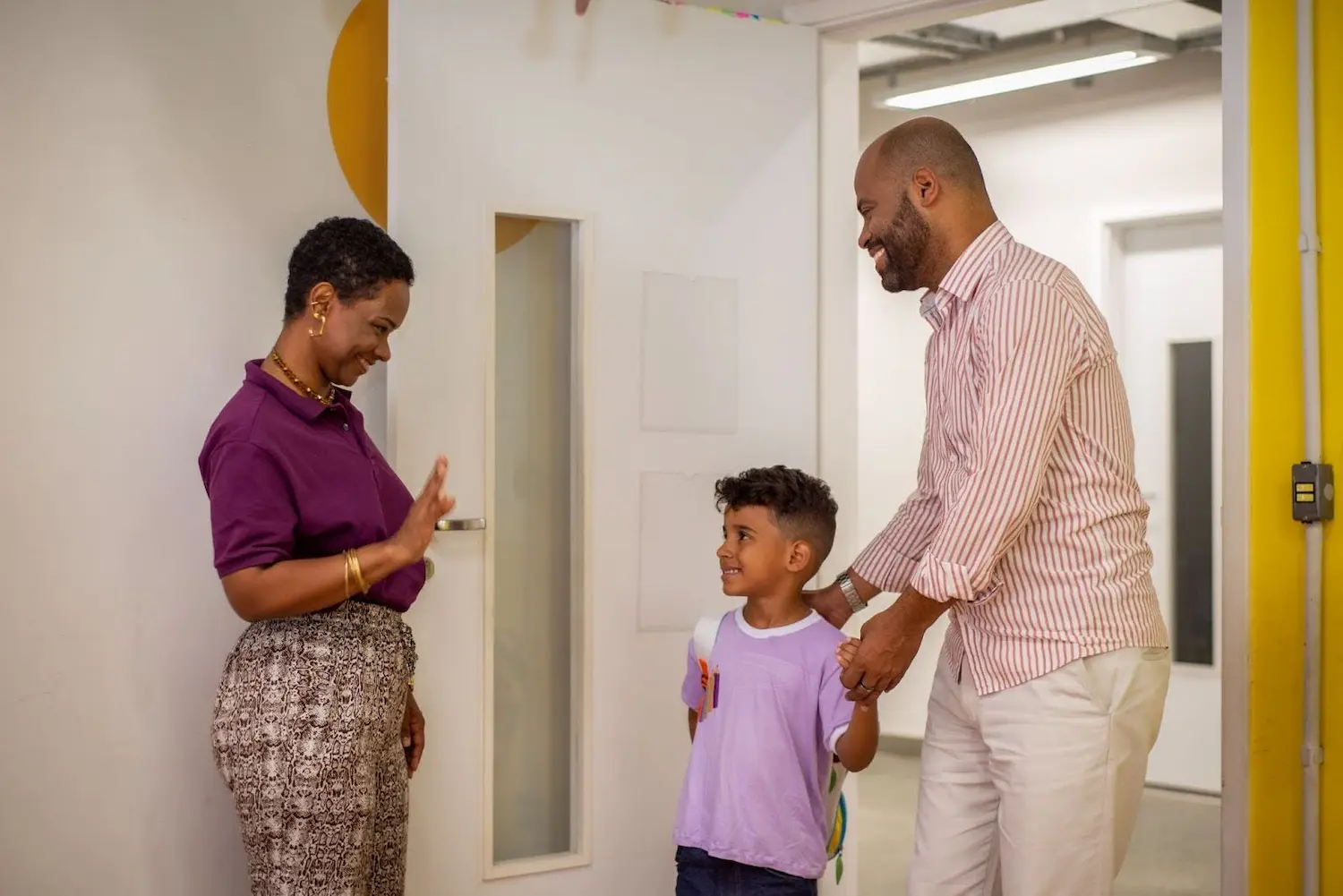 A professora recebe um pai e seu filho após a campanha de matrícula escolar.