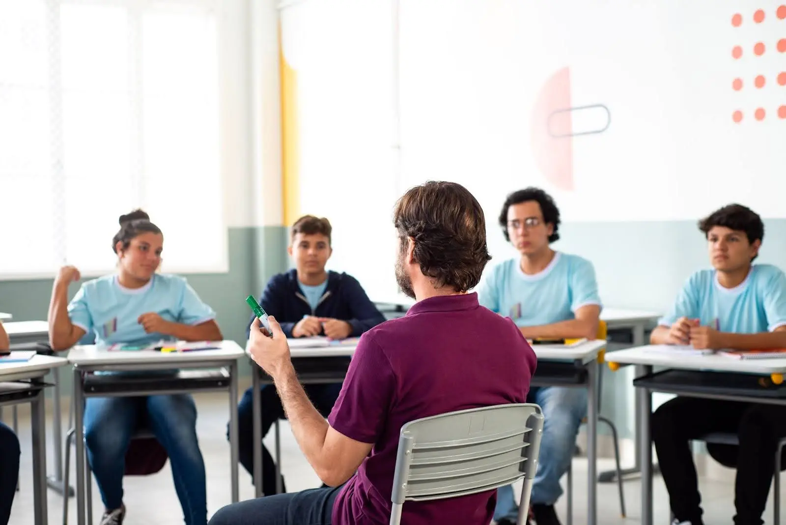 Um professor leciona aula para um grupo de alunos.