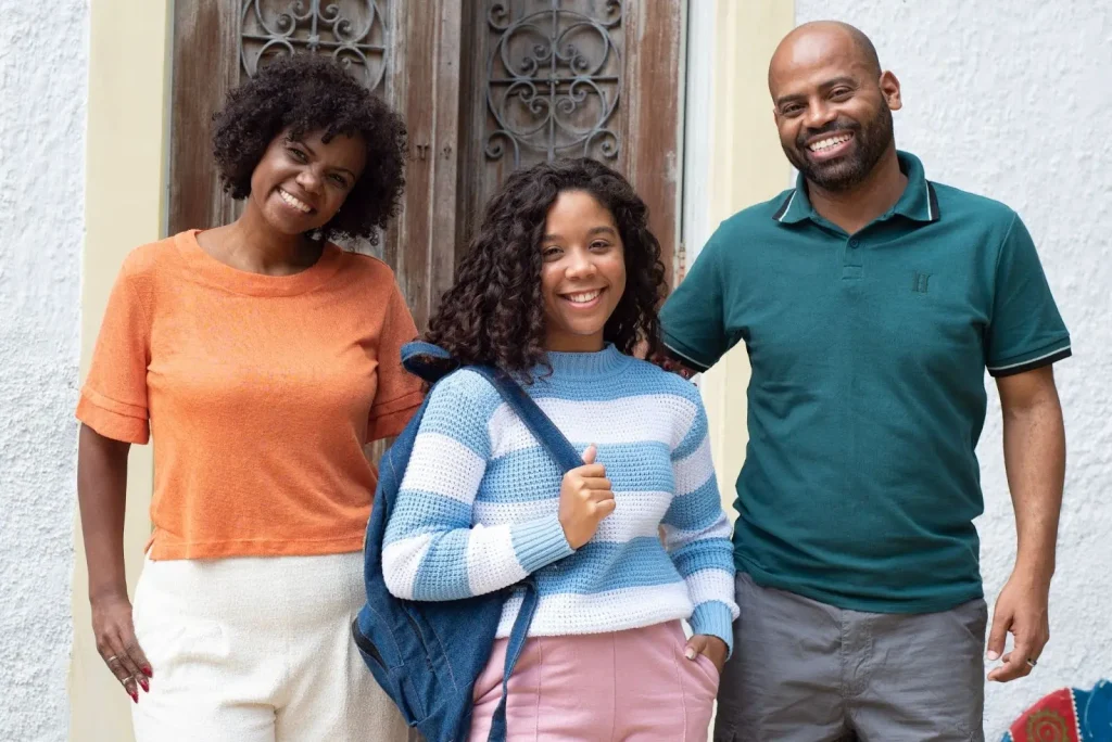 Pais sorridentes com expectativas realistas a respeito da filha adolescente.