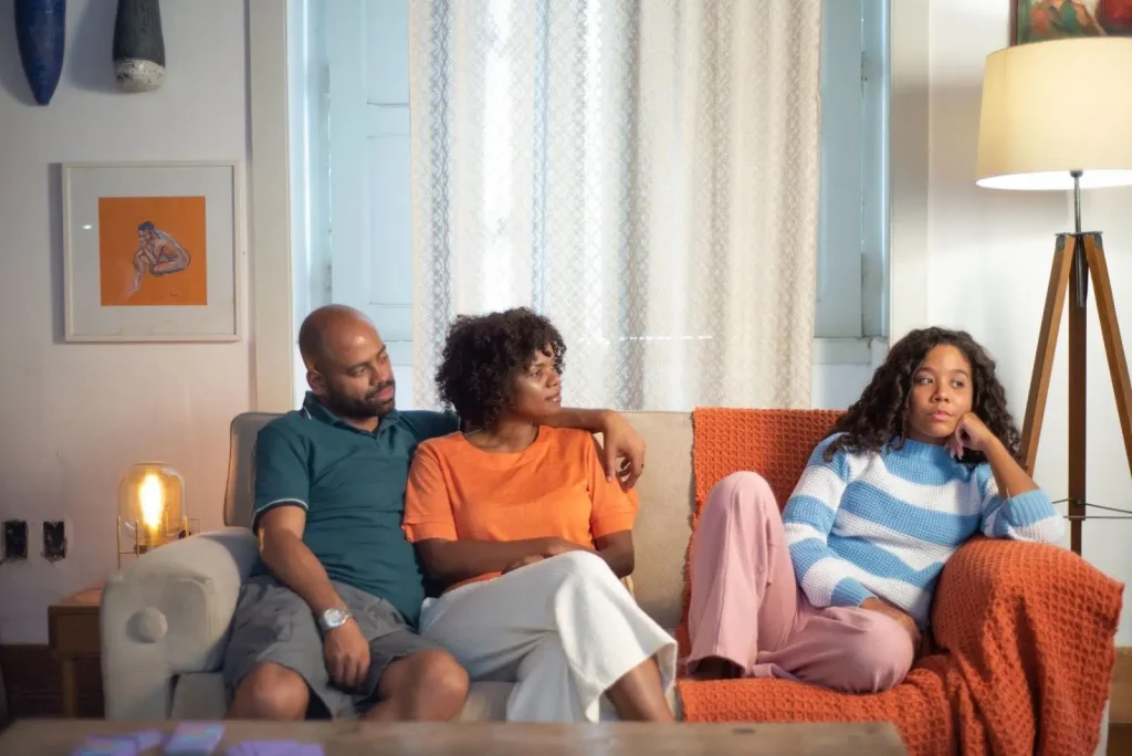 Um pai e uma mãe tenta conversar com a filha sobre um conflito com o irmão.